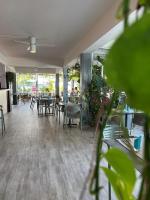 Un comedor con mesas y sillas en un restaurante. en Hôtel Le Grand Bleu, en Saint-Gilles-les-Bains