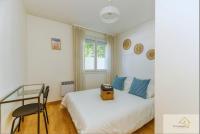 a bedroom with a bed and a chair and a window at Le Mykonos¶ Gare¶ 2Garages ¶Jardin ¶Spacieux in Grenoble