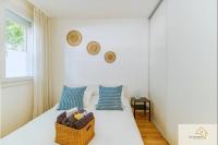 a white bedroom with a bed with blue pillows at Le Mykonos¶ Gare¶ 2Garages ¶Jardin ¶Spacieux in Grenoble