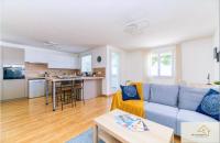 a living room with a blue couch and a kitchen at Le Mykonos¶ Gare¶ 2Garages ¶Jardin ¶Spacieux in Grenoble