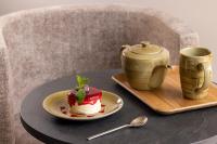 un trozo de pastel en un plato en una mesa en Hôtel Esté, en París