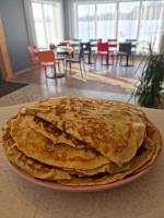 een stapel pannenkoeken op een bord op een tafel bij Auksi motell in Auksi