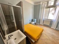 a bathroom with a yellow bed and a shower at Palais Hervé in Cannes