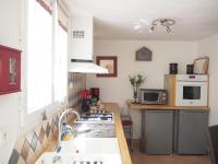 a kitchen with a sink and a stove top oven at Small holiday home with courtyard, Bellegarde in Bellegarde