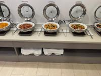 a row of bowls of food on a counter with mirrors at Tamara Jeju hotel in Seogwipo