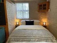 a bedroom with a large bed with two lights on it at A Piece of Life in Bredasdorp