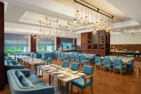 Un comedor con mesas y sillas azules. en Fortune Park, Hoshiarpur - Member ITC Hotels' Group, en Hoshiārpur