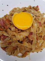 uma tigela de massa com uma colher amarela em um prato em Takatuka Beach Resort em Sipalay