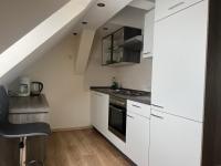 a kitchen with white cabinets and a staircase at Apart Pension Plaue in Brandenburg an der Havel