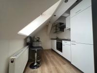 a kitchen with white cabinets and a desk in a loft at Apart Pension Plaue in Brandenburg an der Havel