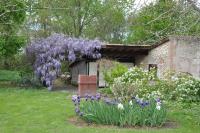 a garden with a wreath of purple flowers at Les Glycines in Saint-Pierre-de-Buzet