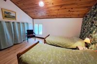 a bedroom with two beds and a wooden ceiling at Les Glycines in Saint-Pierre-de-Buzet