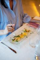 a woman sitting at a table with a plate of food at Hotel Olympus in Caorle