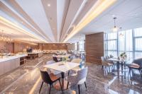 Un restaurante con mesas, sillas y ventanas. en Atour Hotel Wuhan University of Technology Jiedaokou, en Wuhan