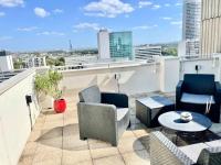 a balcony with chairs and tables on a building at Beautiful apartment with Eiffel tower view in Puteaux