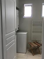 a kitchen with a refrigerator and a window and a chair at LE CAMELIA in Saint-Viâtre