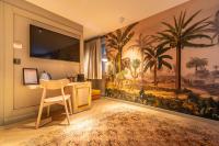 a room with a desk and a large mural of palm trees at The Melegran in Rovinj