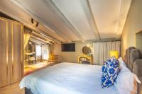 a bedroom with a large white bed and chairs at The Melegran in Rovinj