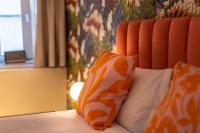 a bed with two orange and white pillows on it at The Melegran in Rovinj