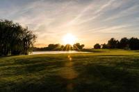 a view of a golf course with the sun setting at Magnifique vue lac au Golf de Pont-Royal in Mallemort