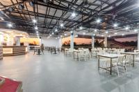 Großes Zimmer mit Tischen, Stühlen und Beleuchtung in der Unterkunft Magsaysay Hillside Resort powered by Cocotel in Magsaysay