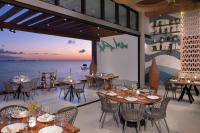 a restaurant with tables and chairs and a view of the ocean at Impression Isla Mujeres by Secrets - Adults Only - All Inclusive in Isla Mujeres