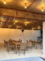 Un restaurante con mesas y sillas de madera en una sala. en On Board Panglao Beach Hostel & Resort with FREE MOTORBIKE, en Dao