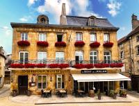 un gran edificio con flores rojas en la parte delantera en Hotel De La Poste, en Langres