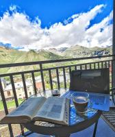 Una mesa con un libro y una computadora portátil y una taza de café. en Kazbegi 4U, en Kazbegi