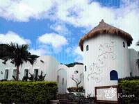 a large white building with a straw roof at Fennel Resort in Checheng