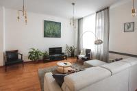 Una sala de estar con un sofá y un televisor. en Bearsleys Downtown Apartments, en Riga