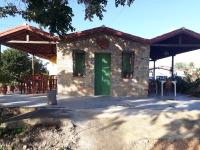una pequeña casa de piedra con una puerta verde en Chalés Rosados, en Serra de São Bento