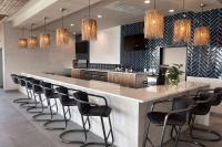 Una cocina con un gran mostrador con sillas alrededor. en The Elm, a Ramada by Wyndham, en Little Elm