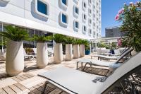 a patio with tables and chairs and a building at Golden Tulip Marseille Euromed in Marseille