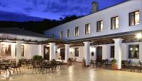 a large white building with tables and chairs at Hotel Pelion Resort in Portariá