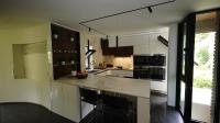 a kitchen with white cabinets and black appliances at Maginifique villa d&#39;architecte sur les bords de Marne tout près de Paris in Le Perreux-Sur-Marne