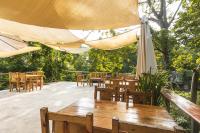 eine Terrasse mit Tischen und Stühlen und einem Sonnenschirm in der Unterkunft Hotel Michanti in El Zonte