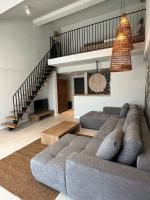 a living room with a couch and a staircase at Luuma in 2 Mai
