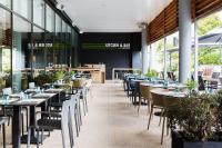 uma sala de jantar com mesas, cadeiras e janelas em Courtyard by Marriott Toulouse Airport em Toulouse