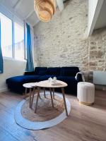 a living room with a table and a blue couch at L&#39;Etoile - Duplex cosy de 50m2 en centre-ville in Nîmes