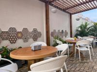 a patio with two tables and white chairs at Azure Lofts & Pool in San Andrés