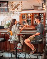 ein Mann und eine Frau sitzen an einer Bar in der Unterkunft Vila da Santa Hotel Boutique & Spa in Búzios