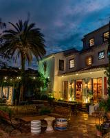 ein Gebäude mit Bänken und einer Palme bei Nacht in der Unterkunft Vila da Santa Hotel Boutique & Spa in Búzios