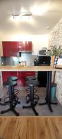 a kitchen with red cabinets and a counter with stools at Montpellier centre-ville in Montpellier