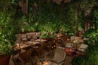 ein Restaurant mit Tischen, Stühlen und Pflanzen in der Unterkunft The Rome EDITION in Rom