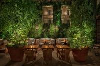 ein Restaurant mit Tischen, Stühlen und Pflanzen in der Unterkunft The Rome EDITION in Rom