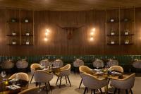 The Leo Kent Hotel, Tucson, a Tribute Portfolio Hotel في توسان: مطعم به طاولات وكراسي ورأس ثور على الحائط