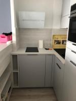 a small kitchen with white cabinets and a stove at Soleil 2023 in Antibes