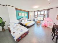a bedroom with two beds and a childs bedroom with a crib at 恆春古城親子民宿 in Hengchun South Gate