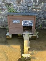 a wooden box with a sign on top of a body of water at Charmante petite maison à Olne in Olne
